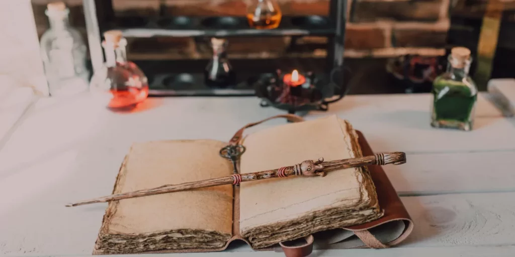 Bacchetta magica appoggiata su libro di incantesimi